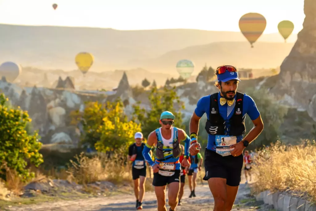 Coureurs traversant les formations rocheuses d'AlUla au lever du soleil lors d'un duathlon